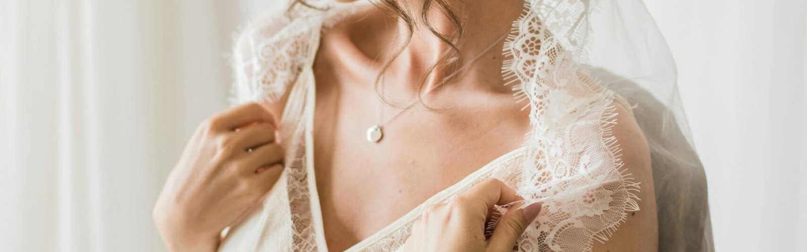 A beautiful bride in bridal lingerie with a lace veil, exuding bridal elegance and charm.